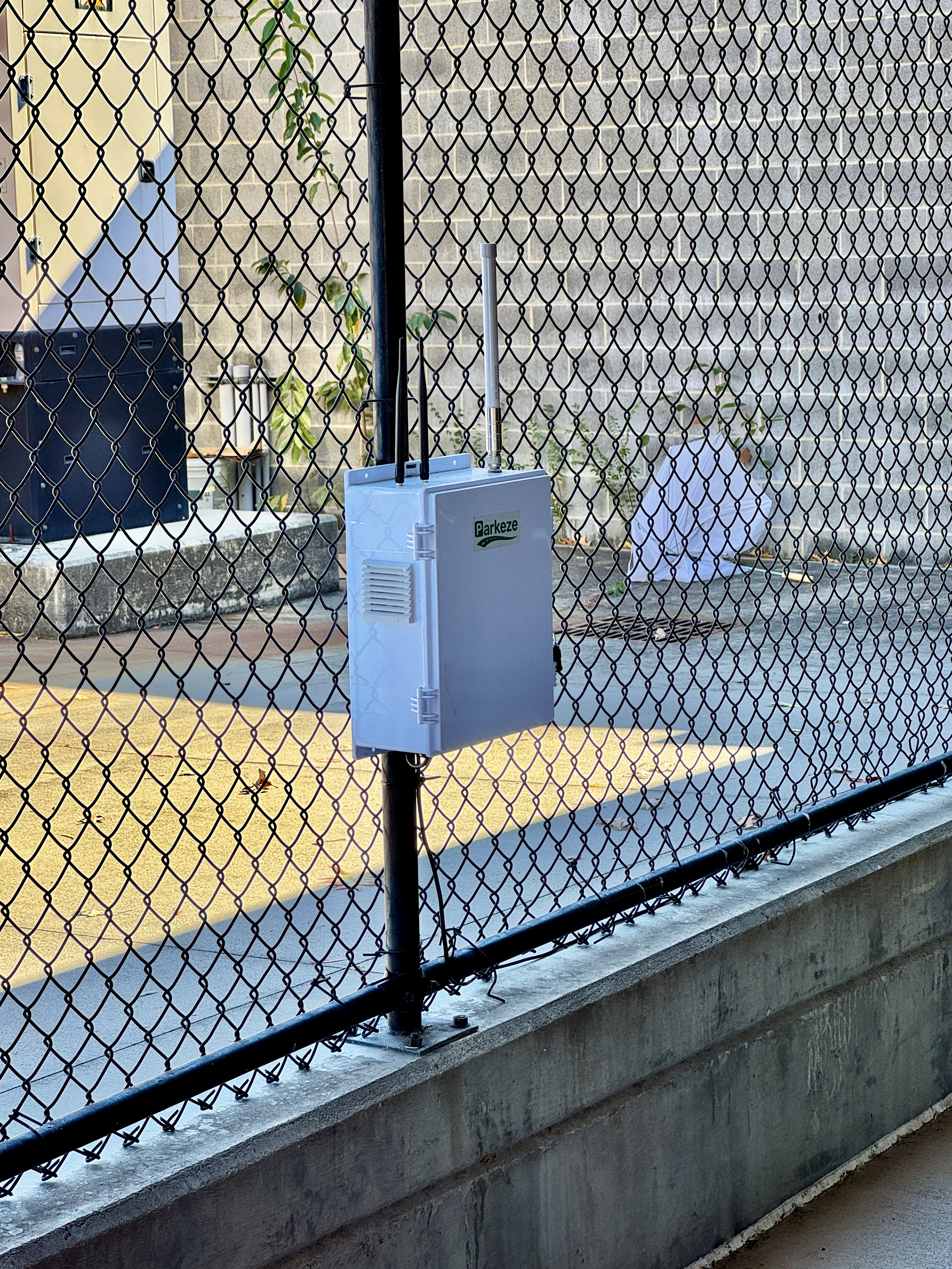 Parkeze gateway enclosure with antennas mounted on a fence